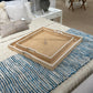 Wicker tray on a bed with pillows and a lamp in the background