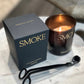 Smoke candle with packaging and black spoon on marble surface