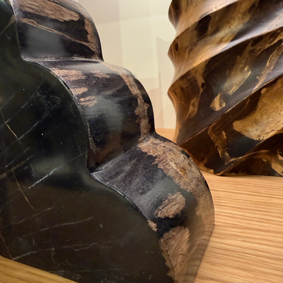 Close-up of large metal gears on a wooden surface