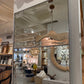 Large mirror reflecting interior decor with furniture and lighting fixtures.