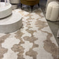 Patterned rug on a floor with furniture in the background