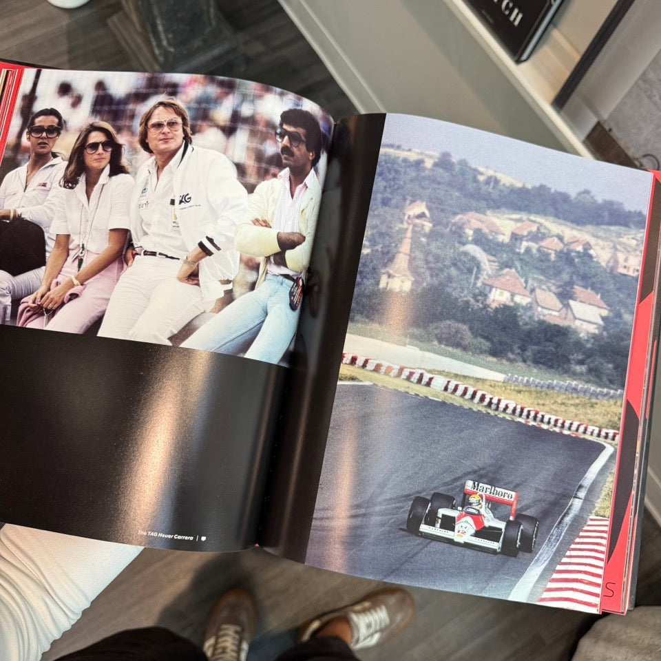 Open book showing a photograph of people and a race track with a car.