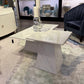 Modern living room with a marble coffee table, decorative items, and a rug.