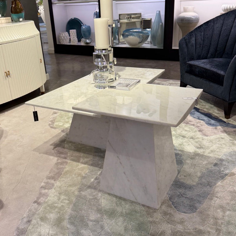 Modern living room with a marble coffee table, decorative items, and a rug.