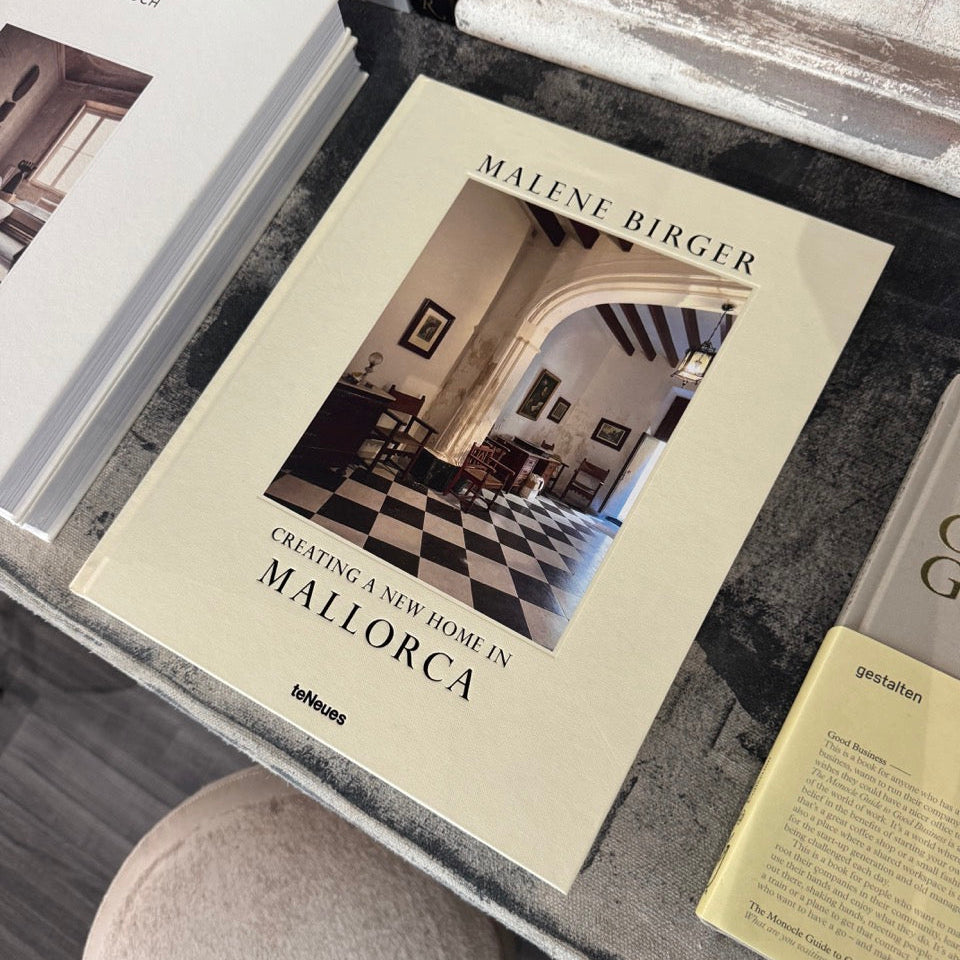 Book titled 'Creating a New Home in Mallorca' by Malene Birger on a surface with other books.