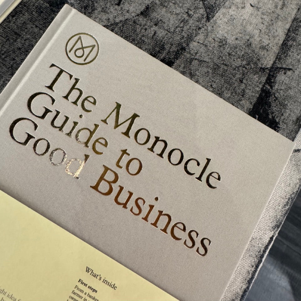 Book titled 'The Monocle Guide to Good Business' on a textured surface