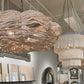 Large beaded chandelier hanging in a room with decor samples and mirrors.