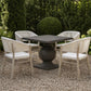 A 4-piece outdoor dining set featuring a square pedestal table and four matching armchairs with distressed off-white frames and white seats, set on a gravel patio in a garden.