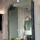 Large wall mirror with decorative frame in a room setting