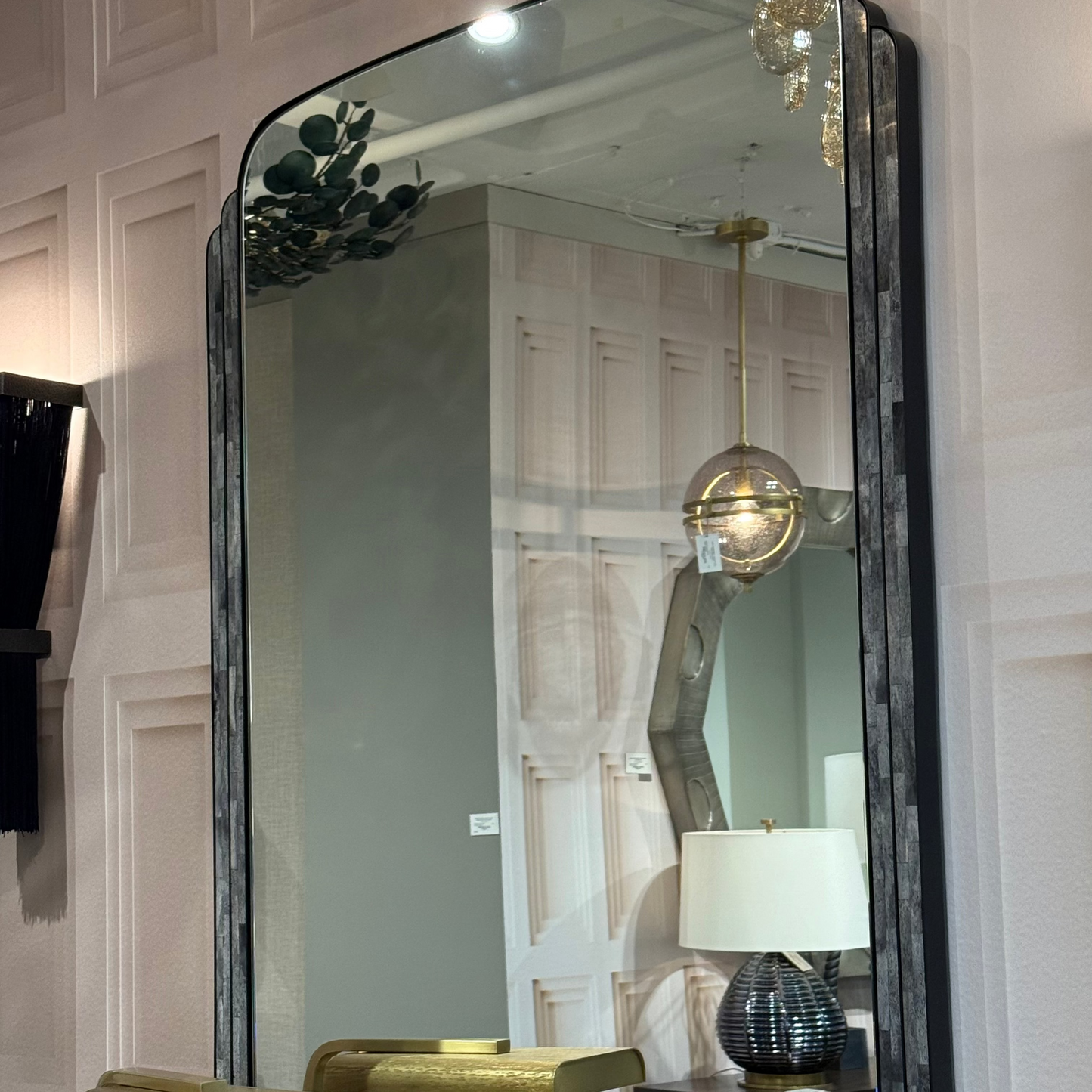 Large wall mirror with decorative frame in a room setting