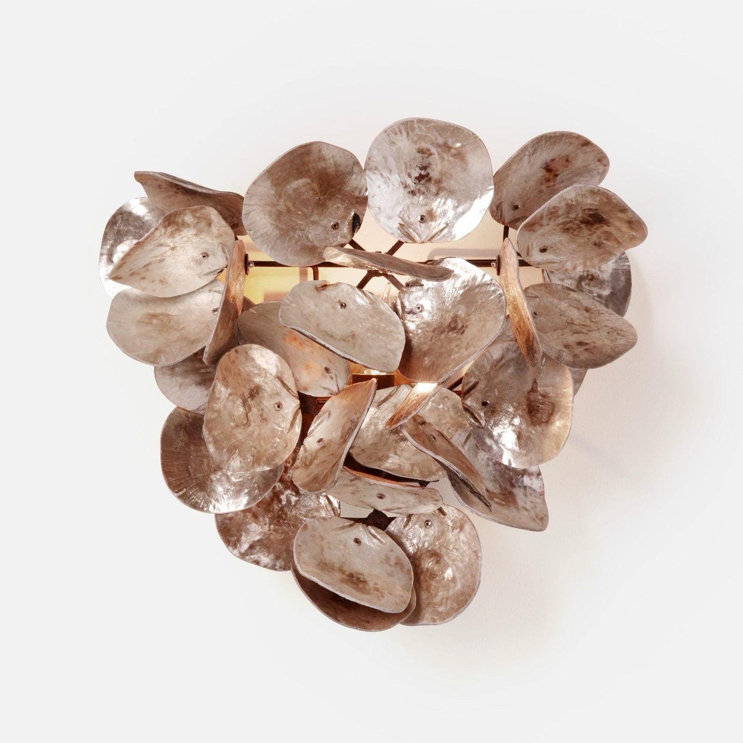 A modern wall-mounted light fixture with clustered metallic bronze and gold leaf-like petals, shown installed on a beige wall in a hallway with dark wood floors.