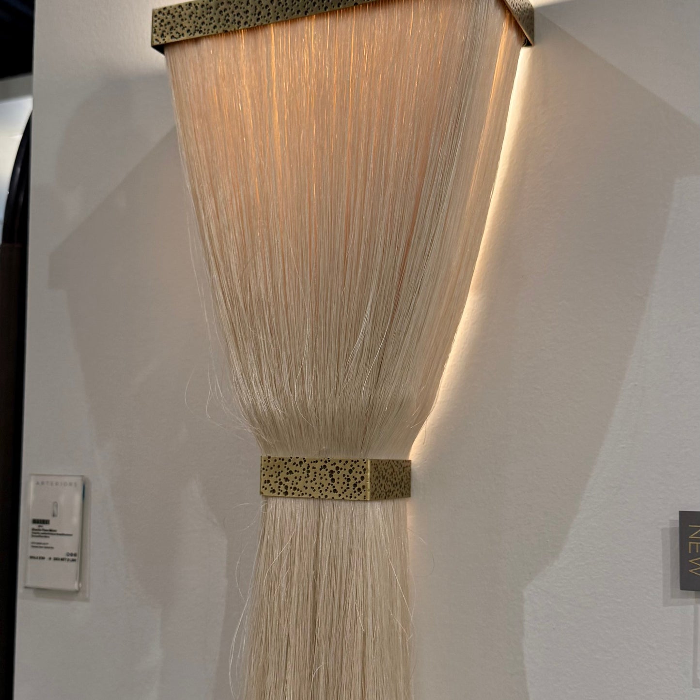 Wall-mounted light fixture with woven design on a white wall