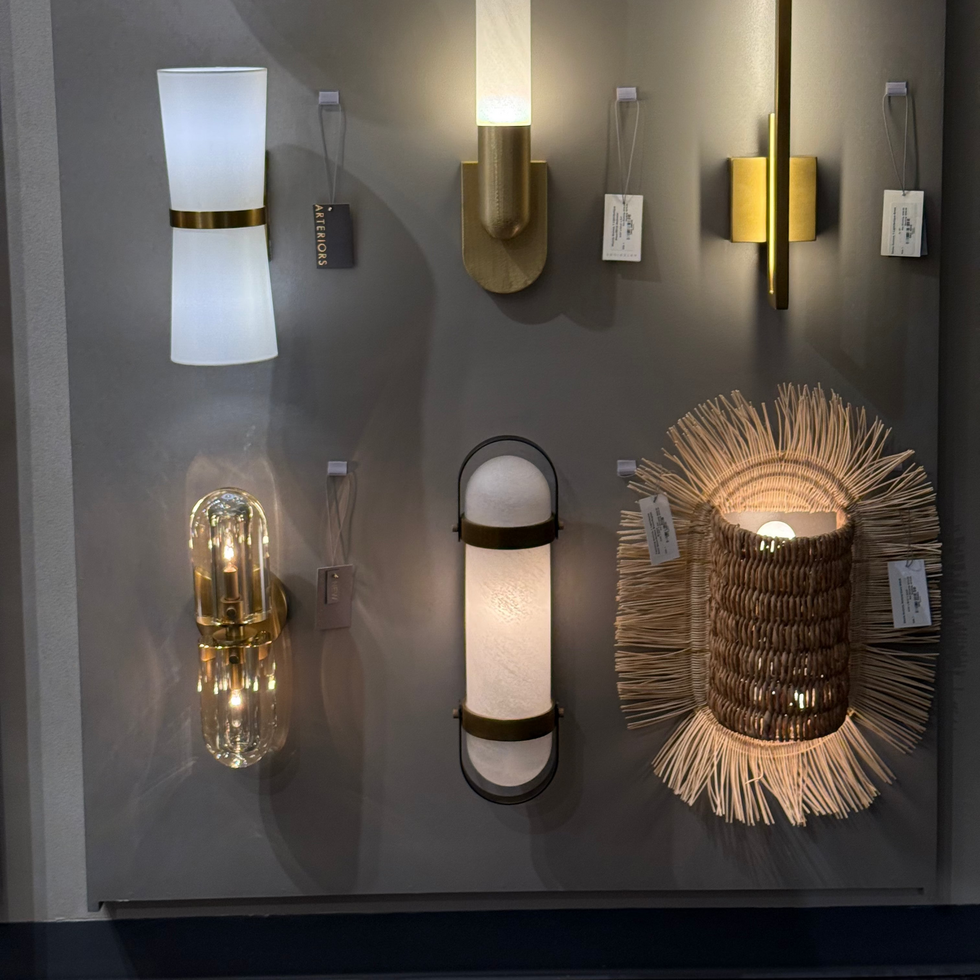 Collection of various wall sconces on a gray wall
