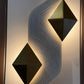 Modern wall sconce with geometric design on a textured wall