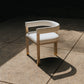 Modern chair with white cushion on a concrete floor with a dark background