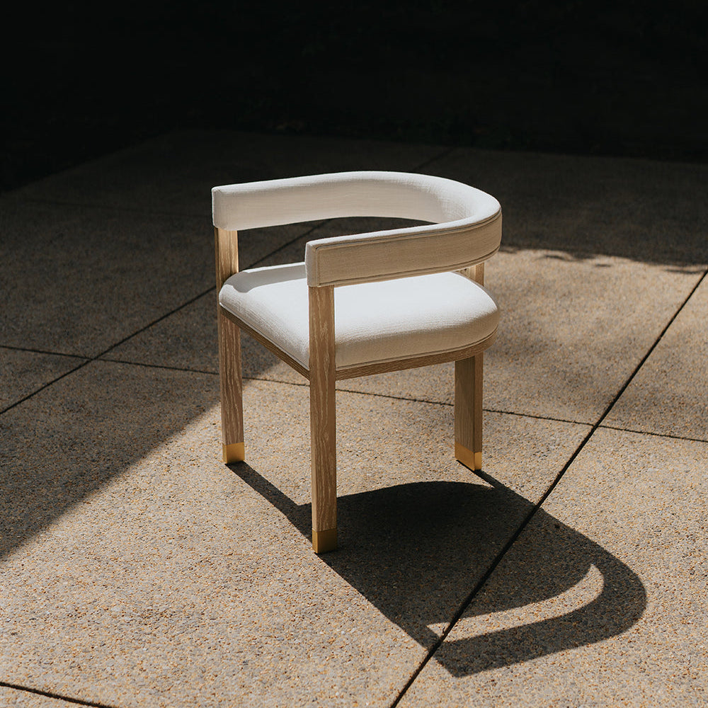 Modern chair with white cushion on a concrete floor with a dark background