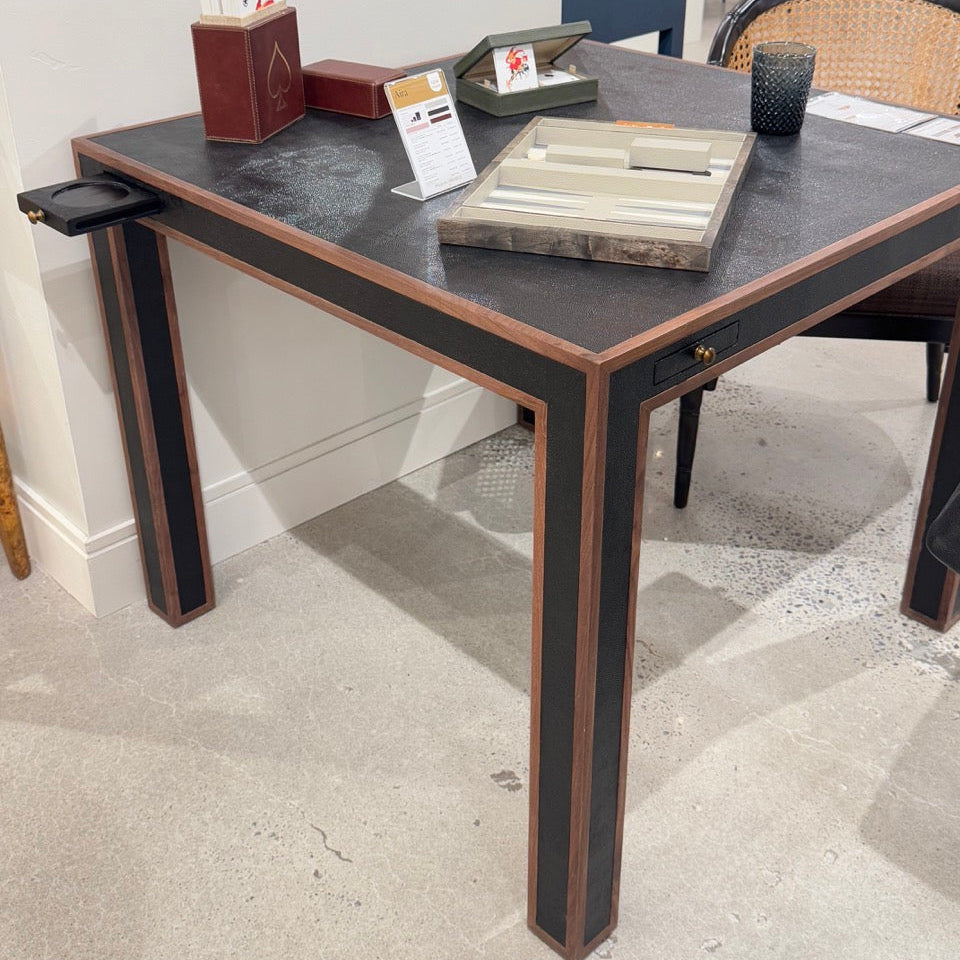 Dining table with black surface and wooden legs in a showroom setting