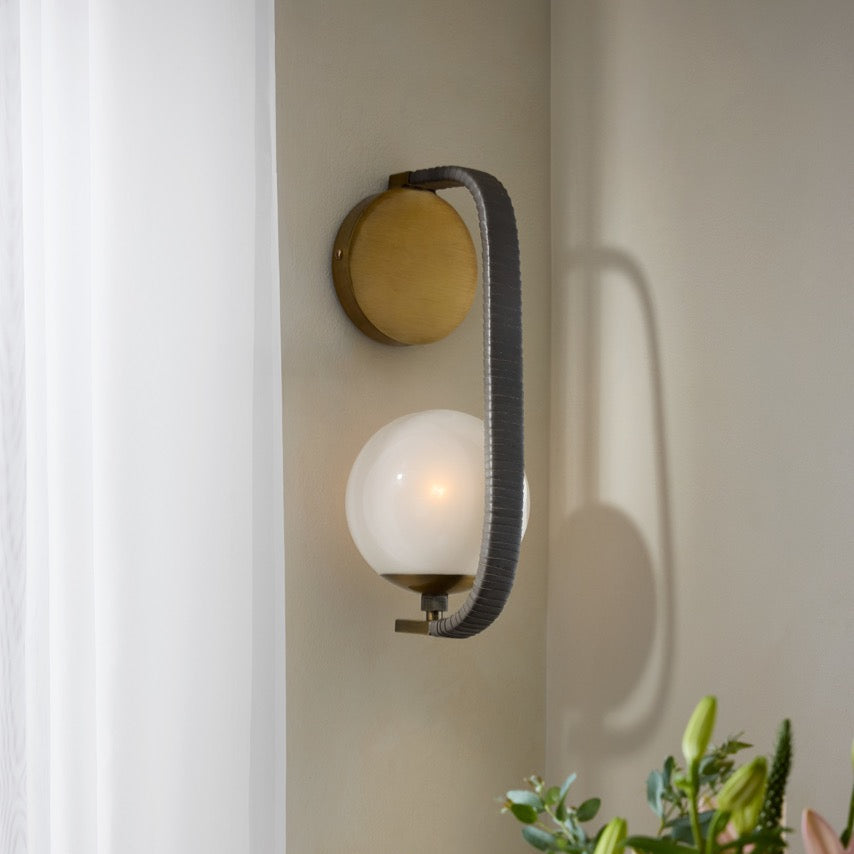 Wall-mounted light fixture with a floral arrangement in the foreground