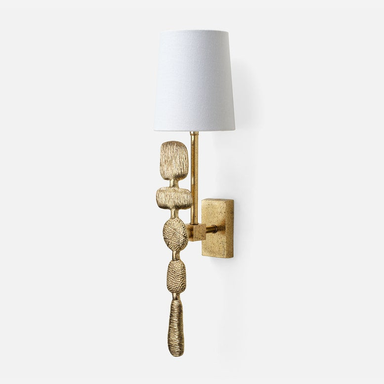 Decorative wall sconce with textured gold base and white shade on a light gray background
