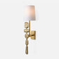 Decorative wall sconce with textured gold base and white shade on a light gray background
