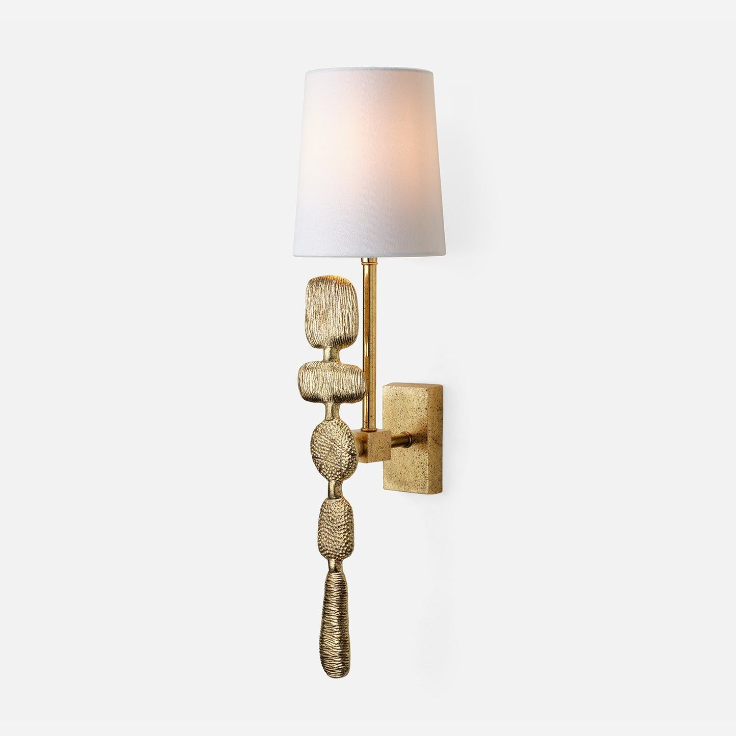 Decorative wall sconce with textured gold base and white shade on a light gray background