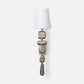 Decorative wall sconce with textured design and white shade on a light gray background
