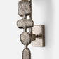 Decorative wall sconce with textured metal design on a white background