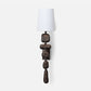 Decorative wall lamp with a textured base and white shade on a white background
