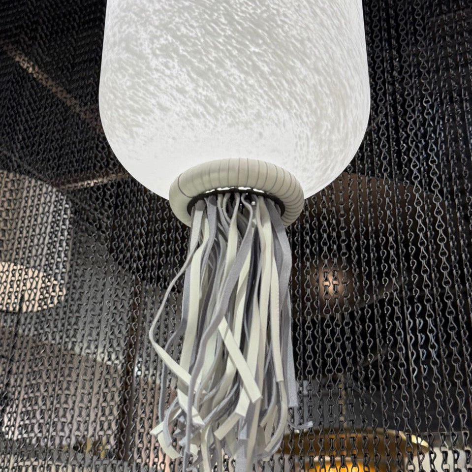 Close-up of a white jellyfish-shaped lamp with a textured surface against a dark background.