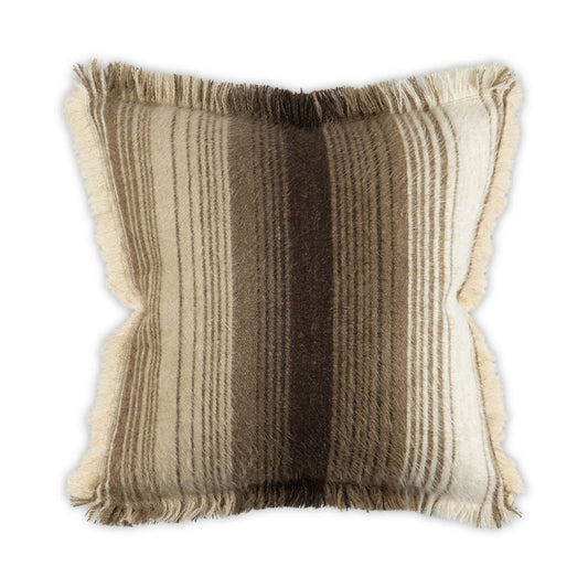 A square throw pillow with a shaggy, faux-fur texture and fringed edges, featuring vertical stripes in cream, beige, and dark brown on a white background.