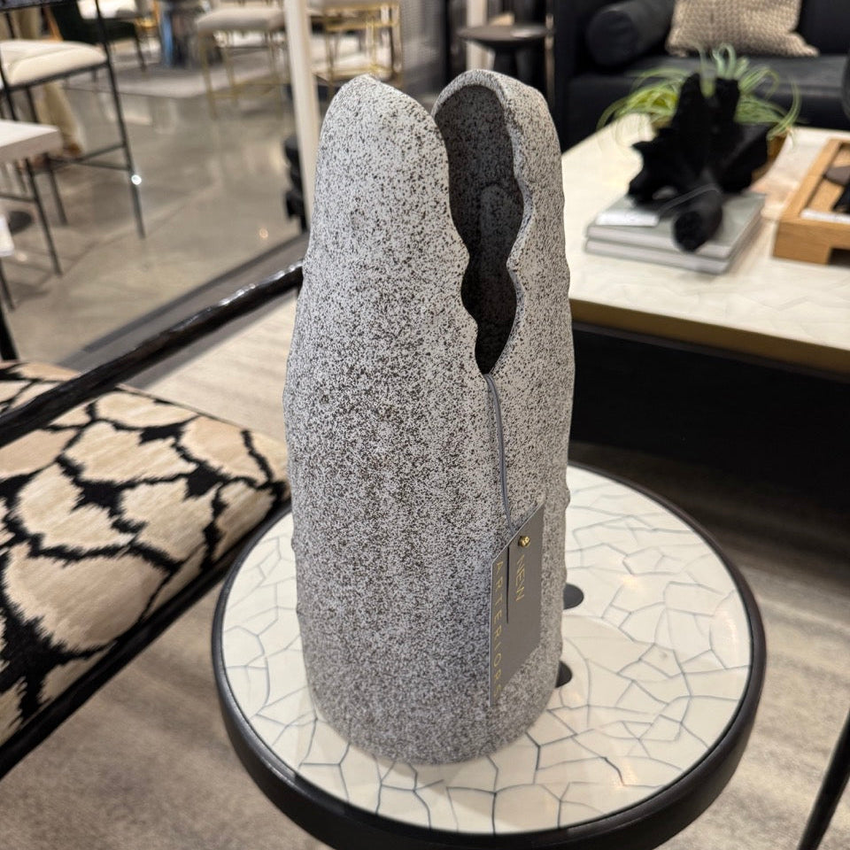 Decorative stone sculpture on a small round table in a room with furniture and decor.