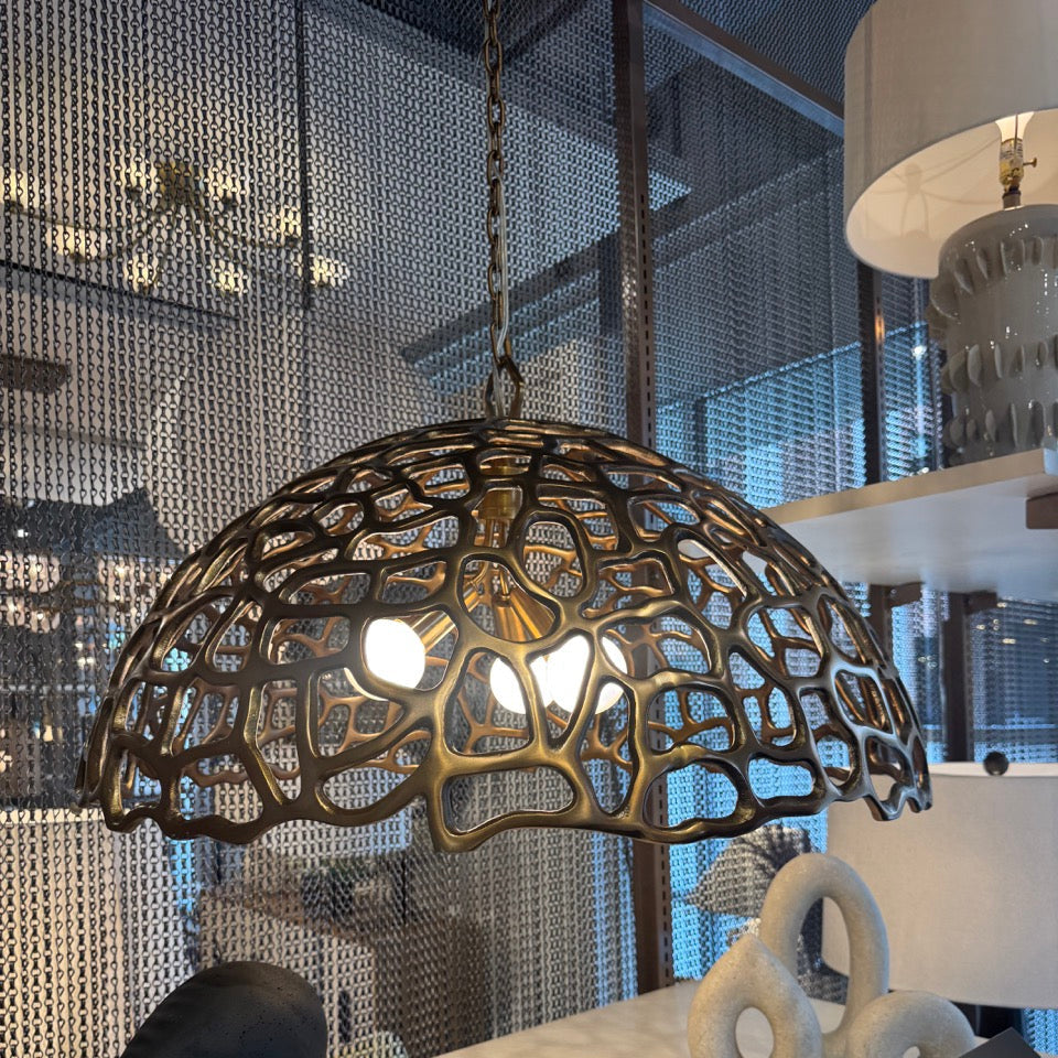 Decorative pendant light fixture with intricate design in a modern interior setting.