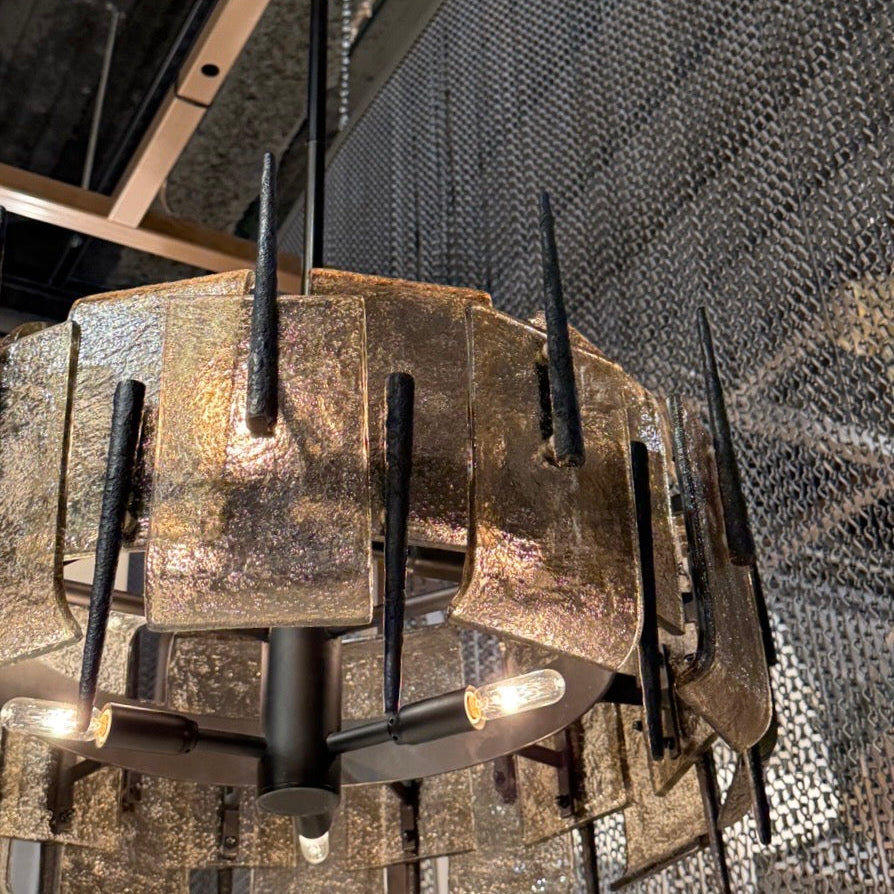 Industrial-style chandelier with metallic finish and black accents hanging from a ceiling.