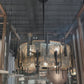 Decorative chandelier hanging from a ceiling with a metallic grid structure.