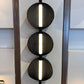 Modern wall sconce with three circular lights on a neutral background