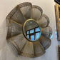 Decorative wall mirror with a sunburst design on a white surface