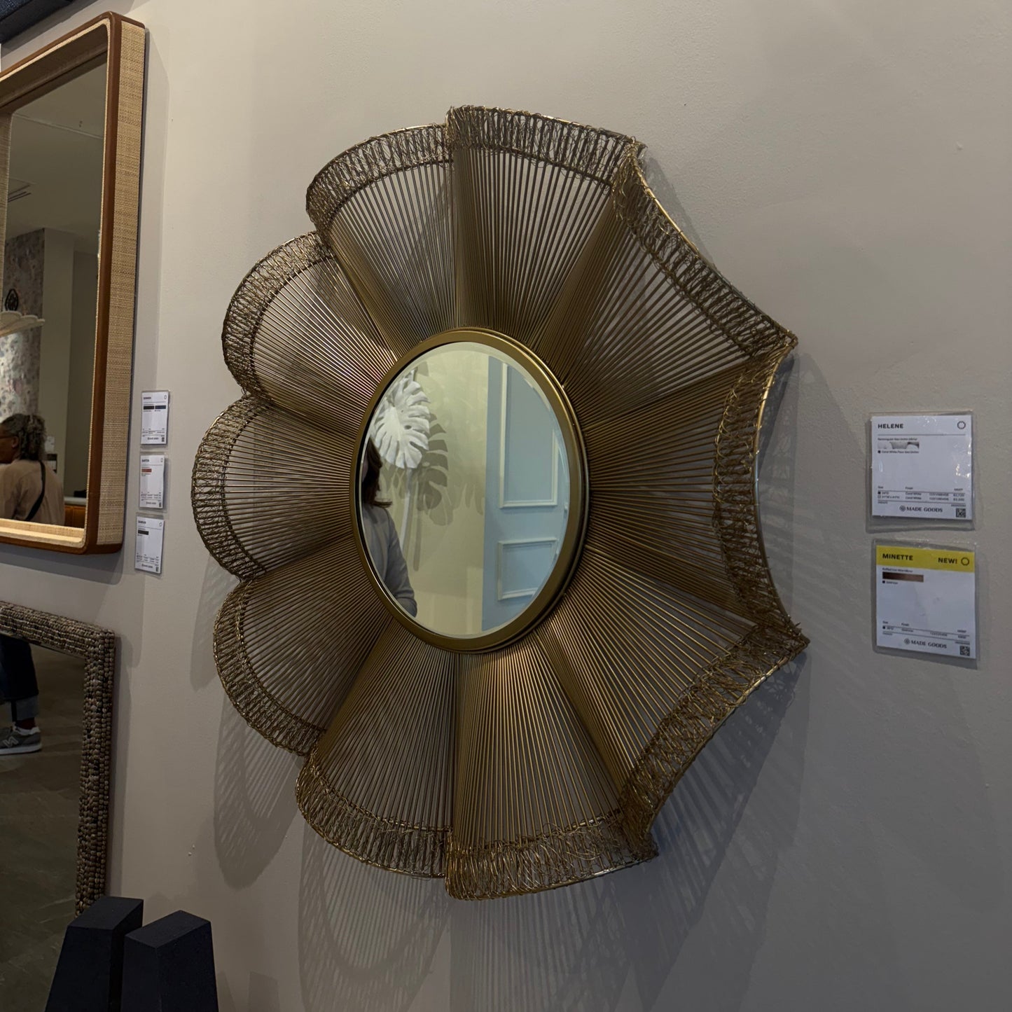 Decorative wall mirror with a wicker-like frame on a wall.