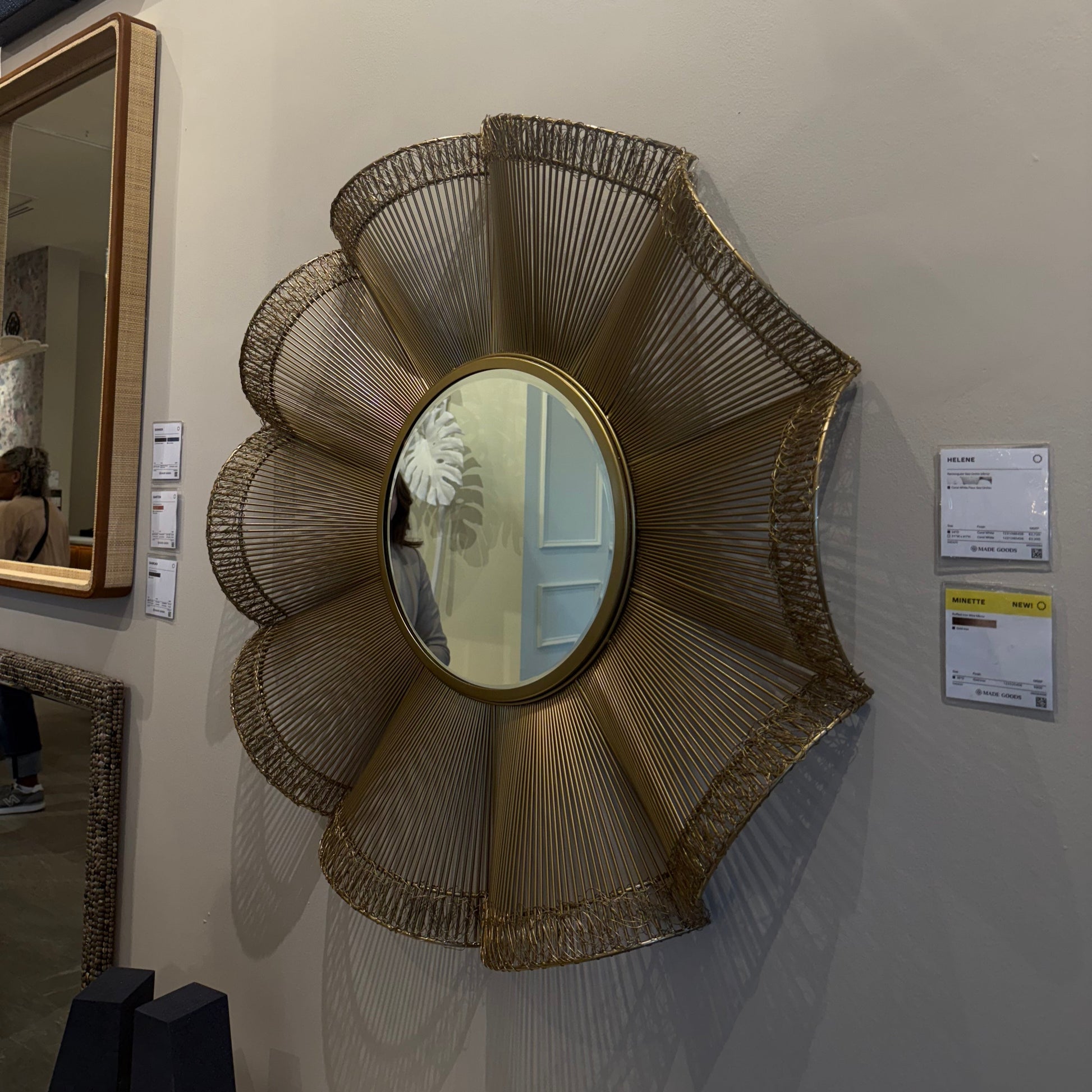 Decorative wall mirror with a wicker-like frame on a wall.