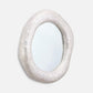 Decorative mirror with a textured, off-white frame on a light gray background