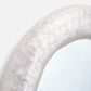 Close-up of a textured white circular object on a light gray background