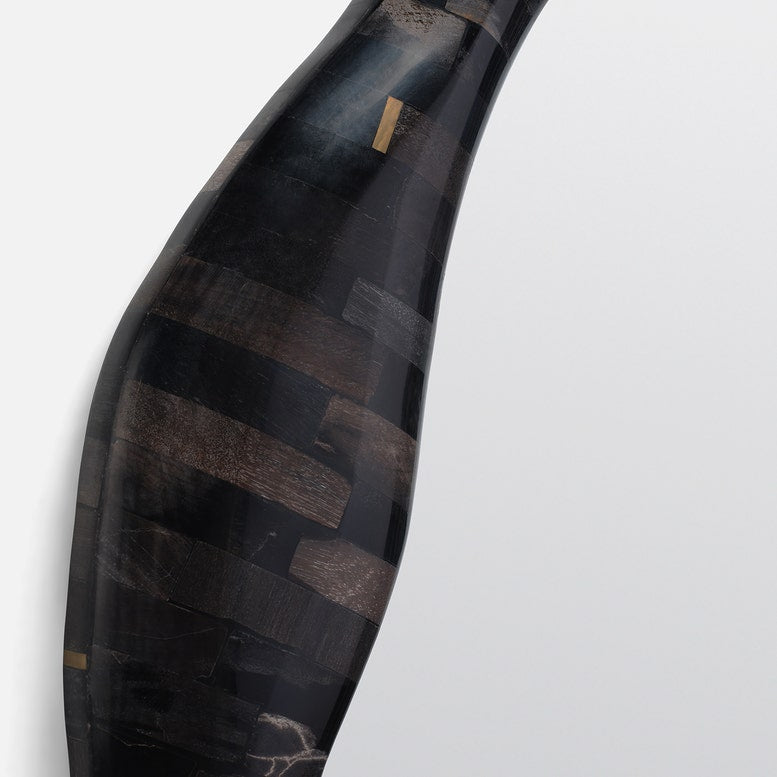 Decorative vase with black and brown striped pattern on a light gray background