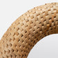 Close-up of a woven wooden ring on a light gray background