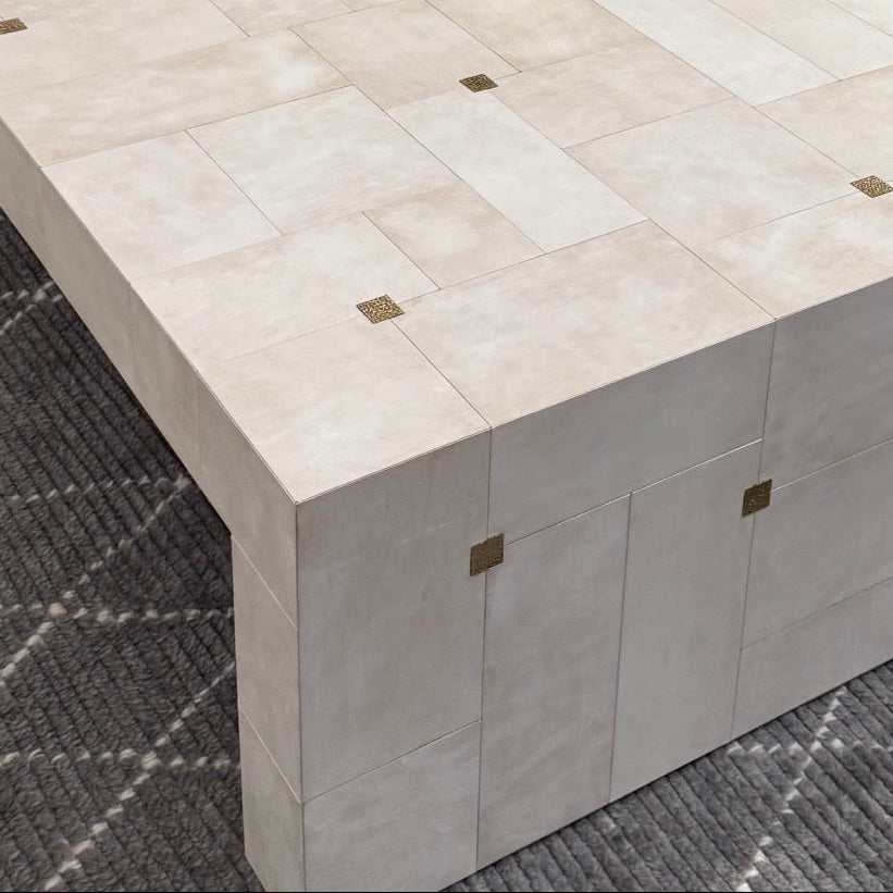 Beige coffee table with decorative items in a room setting