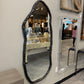 Decorative mirror with unique frame on a wall in an indoor setting