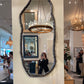 Decorative mirror with a textured frame in a showroom setting