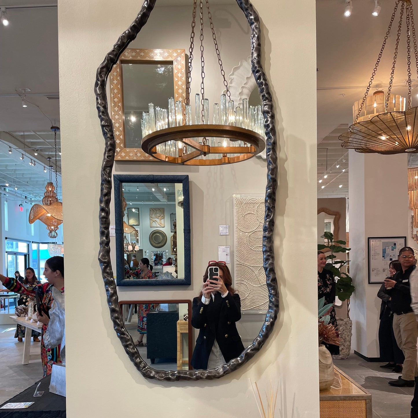 Decorative mirror with a textured frame in a showroom setting