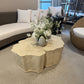 Decorative stone coffee table with flowers in a modern living room setting.