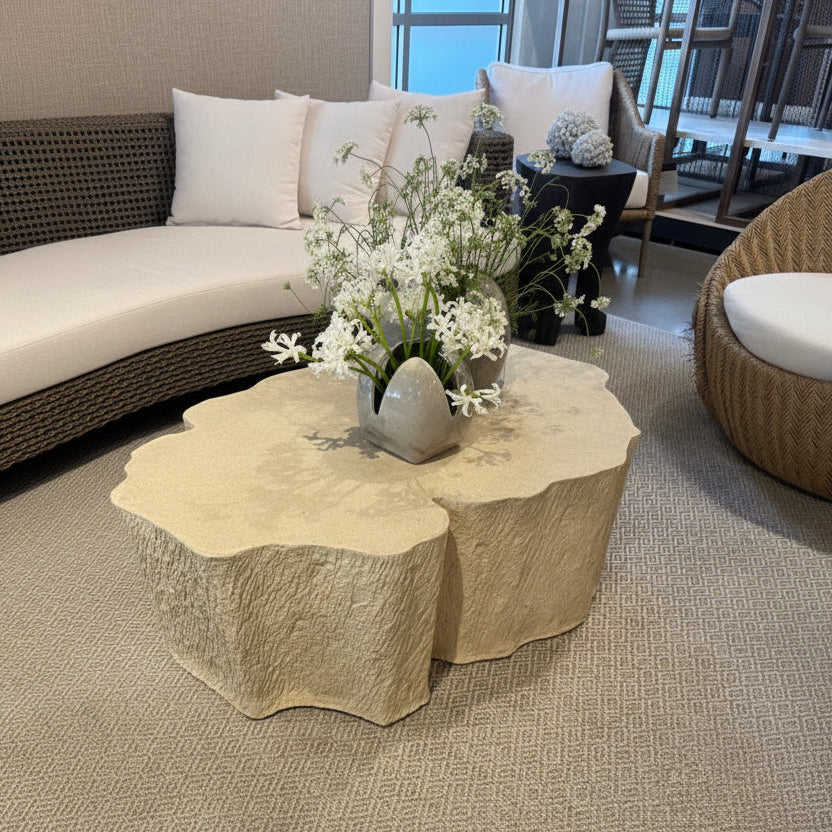Decorative stone coffee table with flowers in a modern living room setting.
