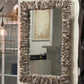 Decorative mirror with a textured frame in a room setting