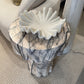 Decorative stool with marble-like pattern and ruffled top in a store setting